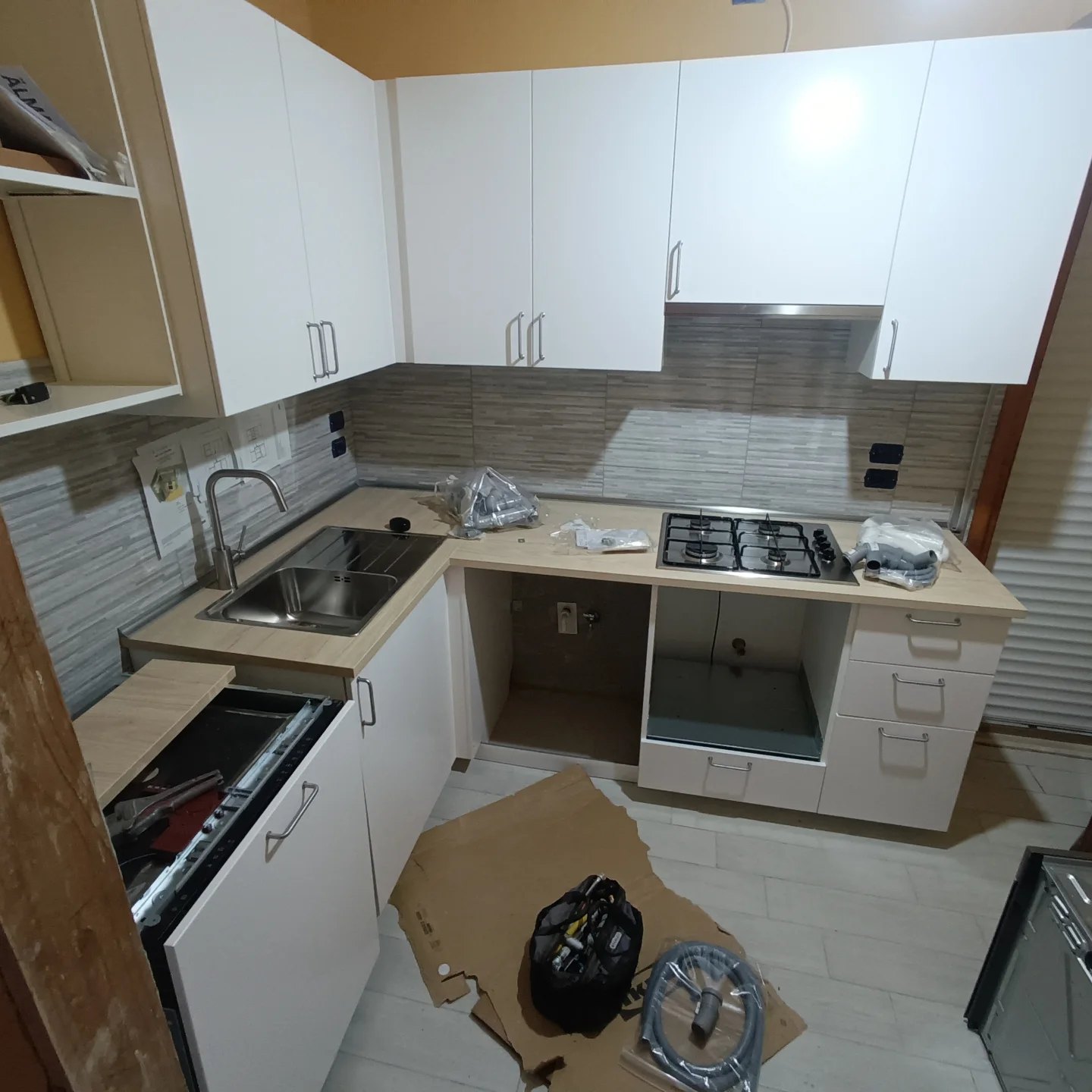 Cucina durante l’installazione con lavello e materiale idraulico sul piano
